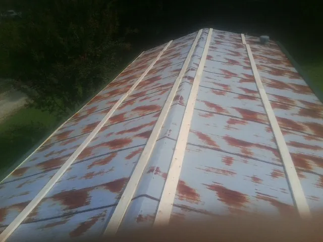 Rusted metal roof panels with new wood purlins before replacement — Storm Damage Roof Repair in Laurens by Roofing Brothers