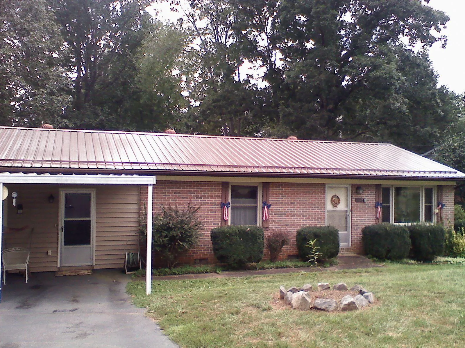 Bronze metal roof and carport on a brick ranch home — Roof Repair work by our crew in Laurens